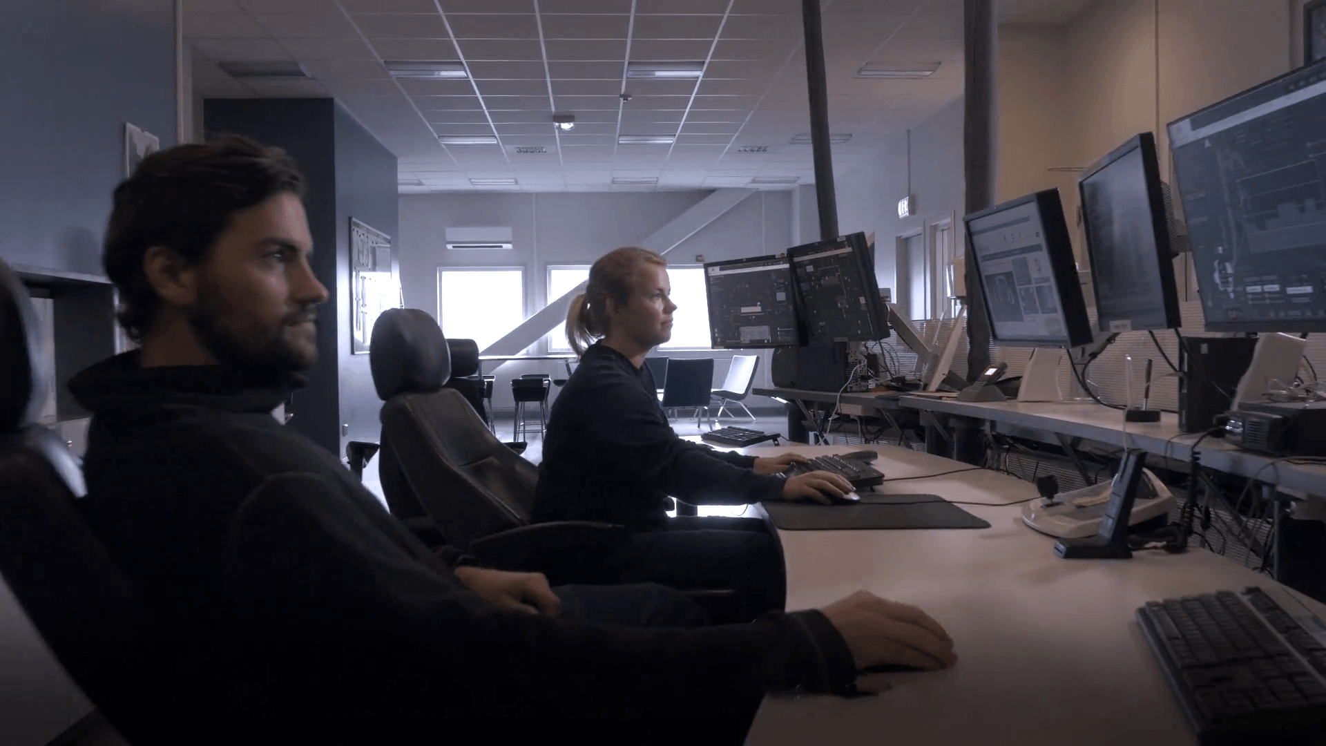 Operators monitoring mine operations on screens inside an integrated remote operations centre (IROC)